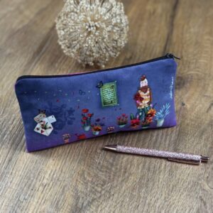 Federmäppchen Blumenliebe auf einem Holztisch mit Stift davor, florales Motiv, dargestellt sind Blumen und ein Mann