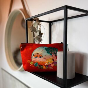 Schminktasche Freiheit Indien, Wandregal vor einer Kerze mit Motiv einer Frau in der Natur an einen Baum gelehnt, dazu ein kleiner Bus